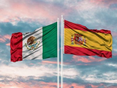 banderas de méxico y españa sobre atardecer