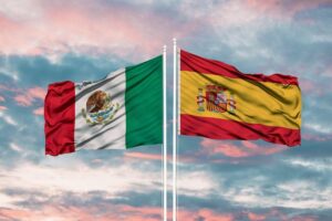 banderas de méxico y españa sobre atardecer